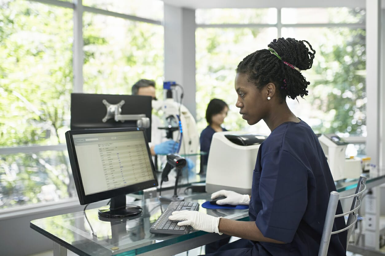 A woman in a hospital reviews secure records on a computer