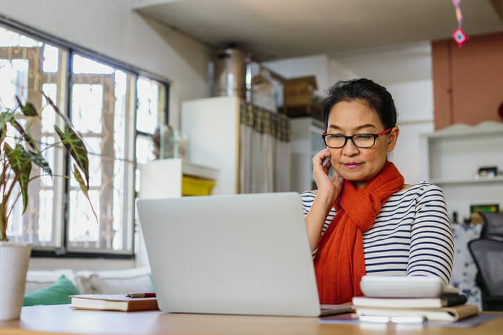August BLS report. A woman looks at her laptop in her living room.