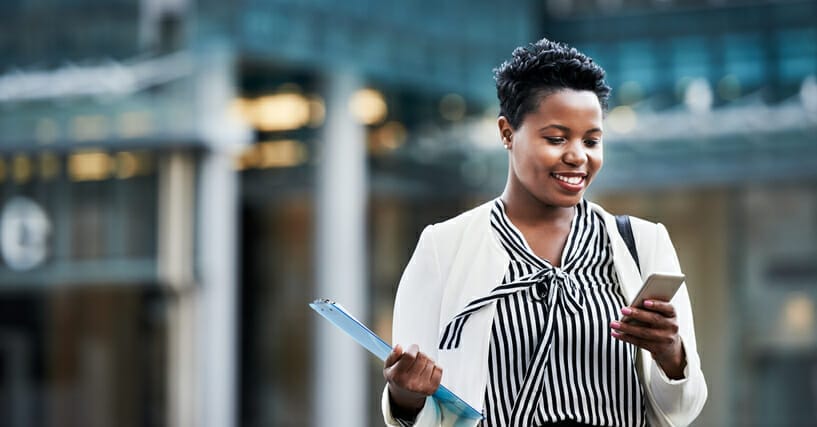 Faster hiring with Apploi: a businesswoman smiles at her phone