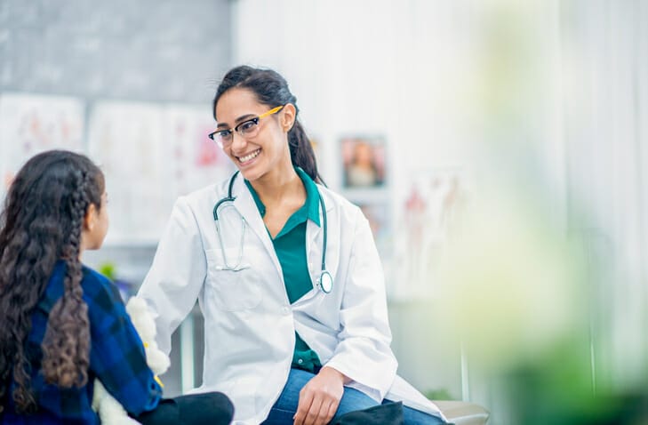 Healthcare background checks. A healthcare worker smiles at a young girl.