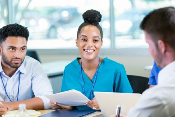 Hiring period. Smiling healthcare workers look over paperwork together.