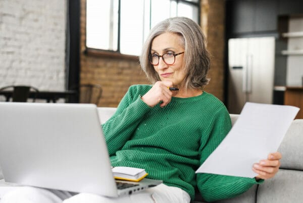 How to post a job on facebook. A woman reviews something on her computer.