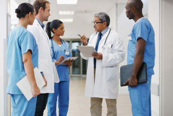 A group of diverse doctors and nurses discuss DEI initiatives.