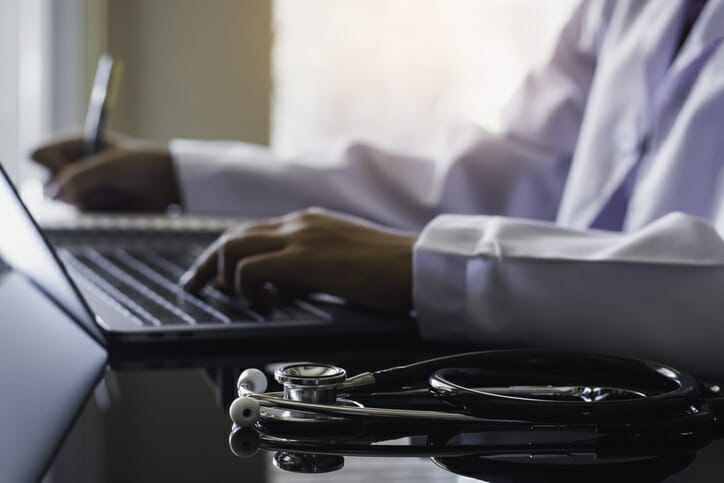 A doctor works on a computer