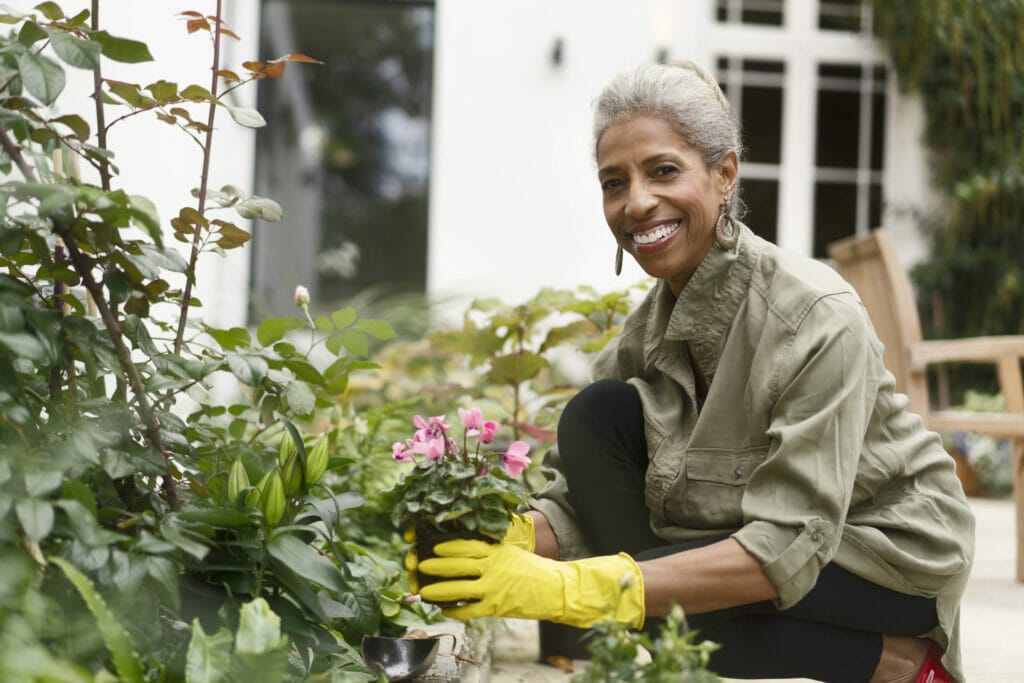 Happy retired senior woman gardening in back yard